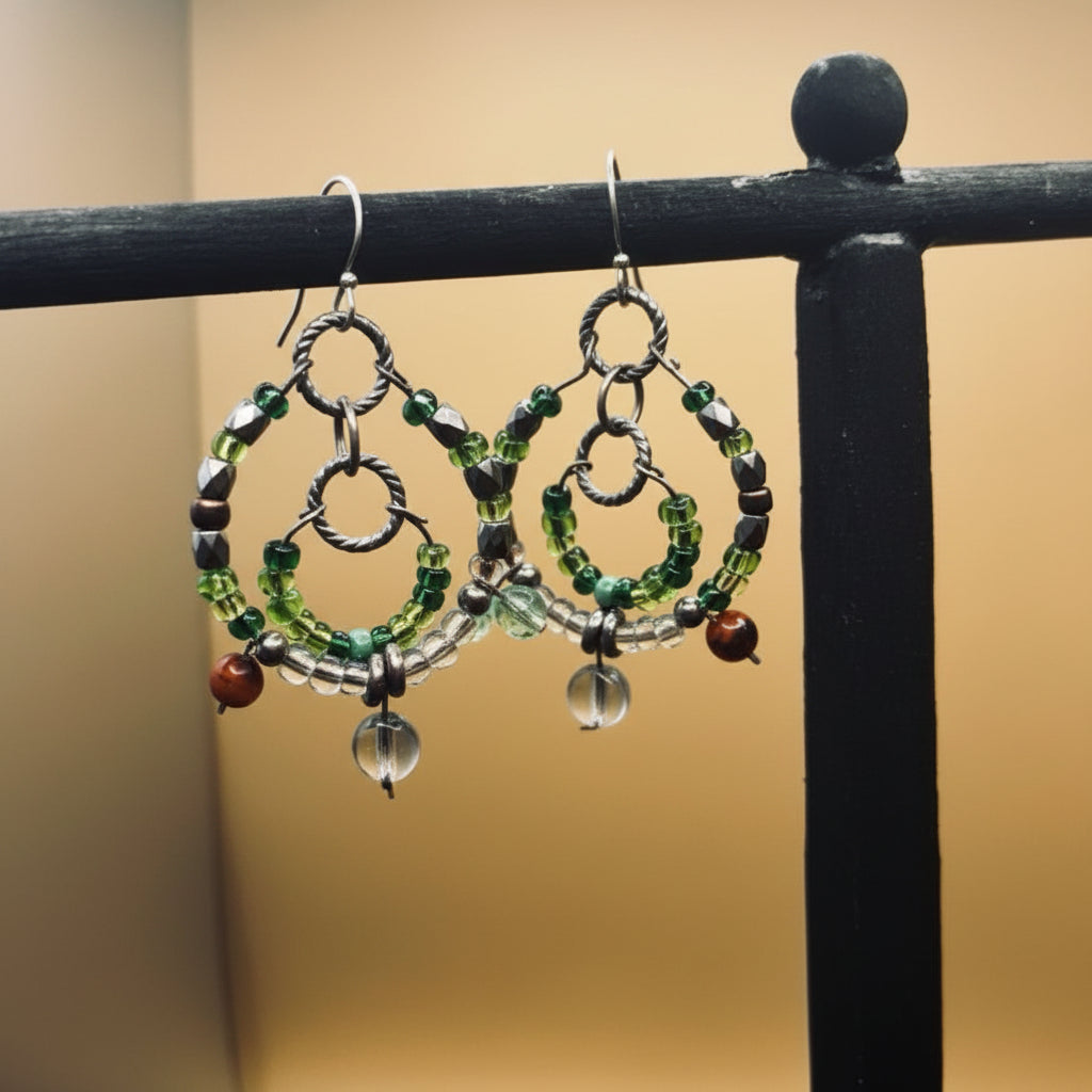 Pair of beaded earrings on a black stand against a beige background